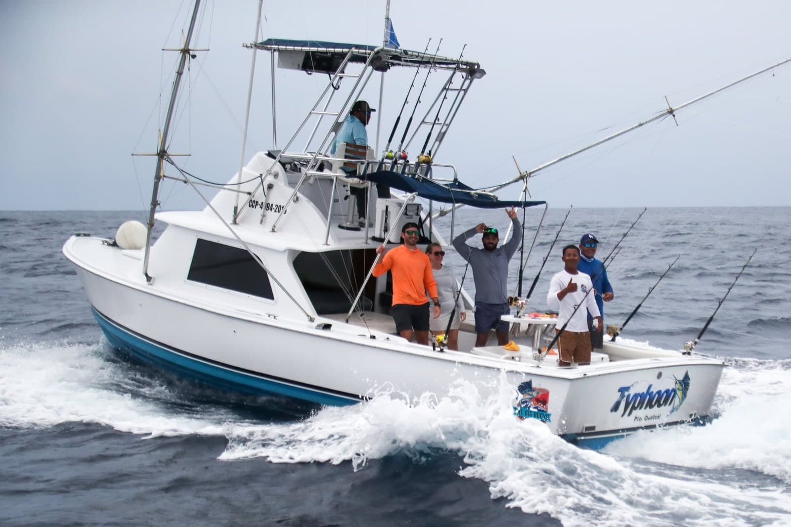 The Big Buoys boat Typhoon running with the crew waving off Puerto San José, Guatemala