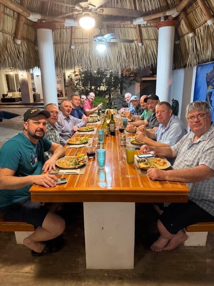 Guests sharing a chef-prepared meal at the long dining table in the Big Buoys villa, Guatemala